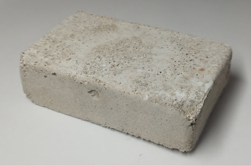 Vzorek bloku z recyklátu zpevněného pomocí produktů vytvořených bakterií Sutcliffiella cohnii.
